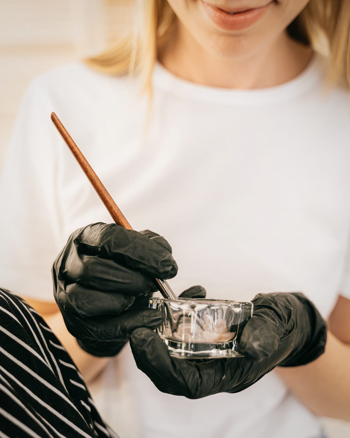 Pinsel trägt Farbe auf eine Haarsträhne auf